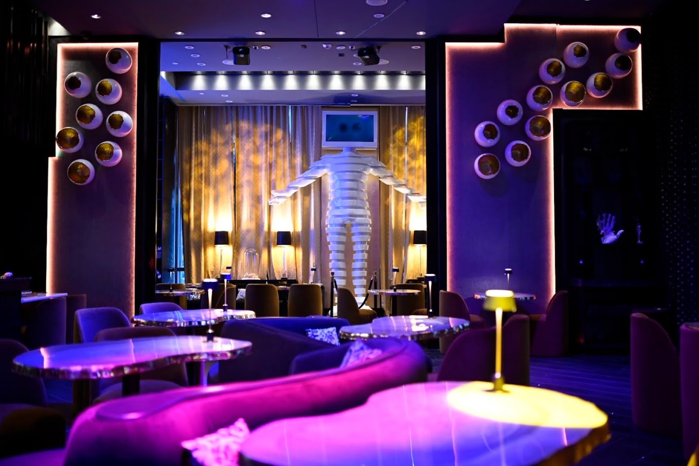 black and purple nightclub with couches and lamps